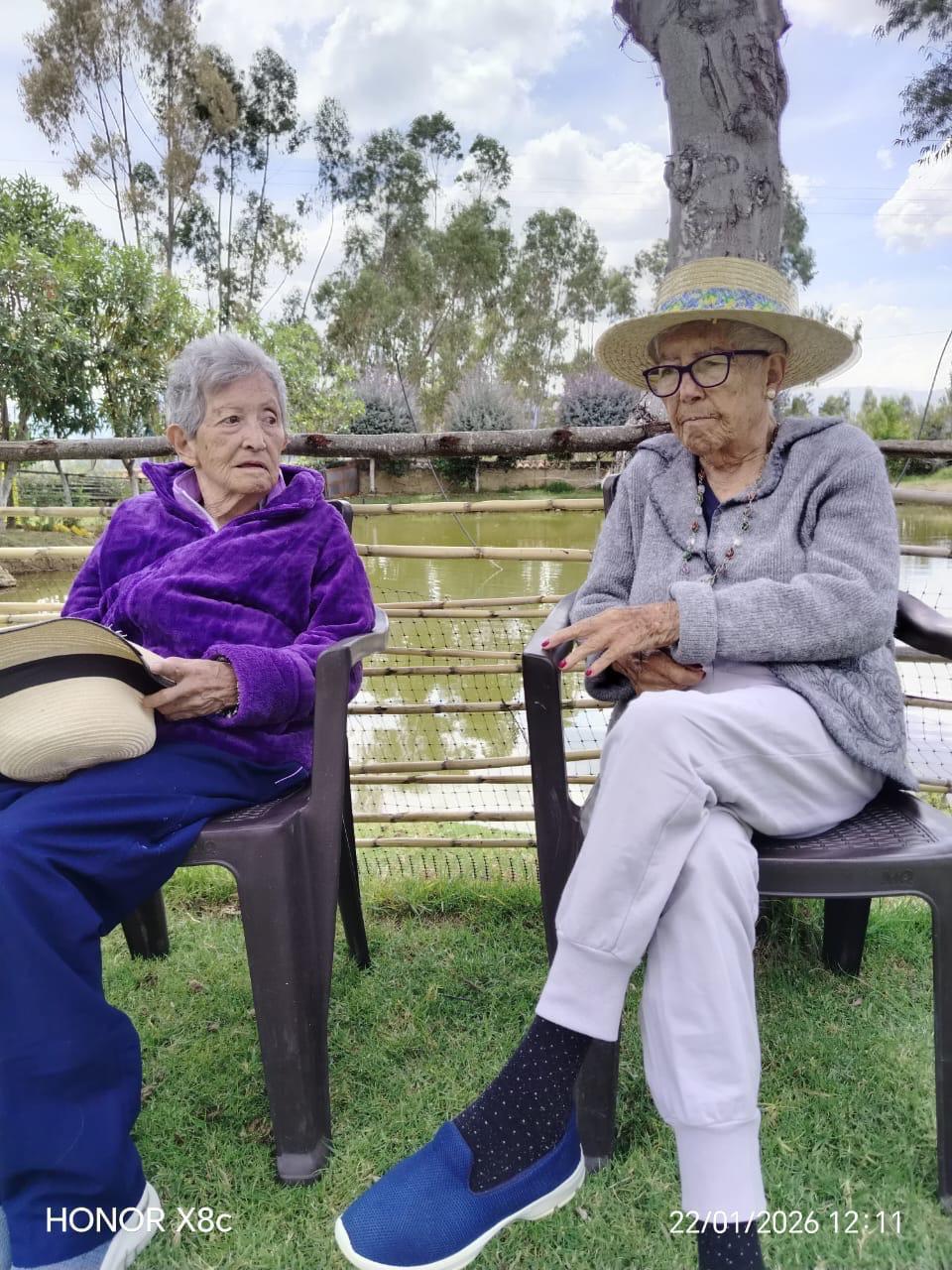 Dos residentes conversando junto al lago del centro campestre