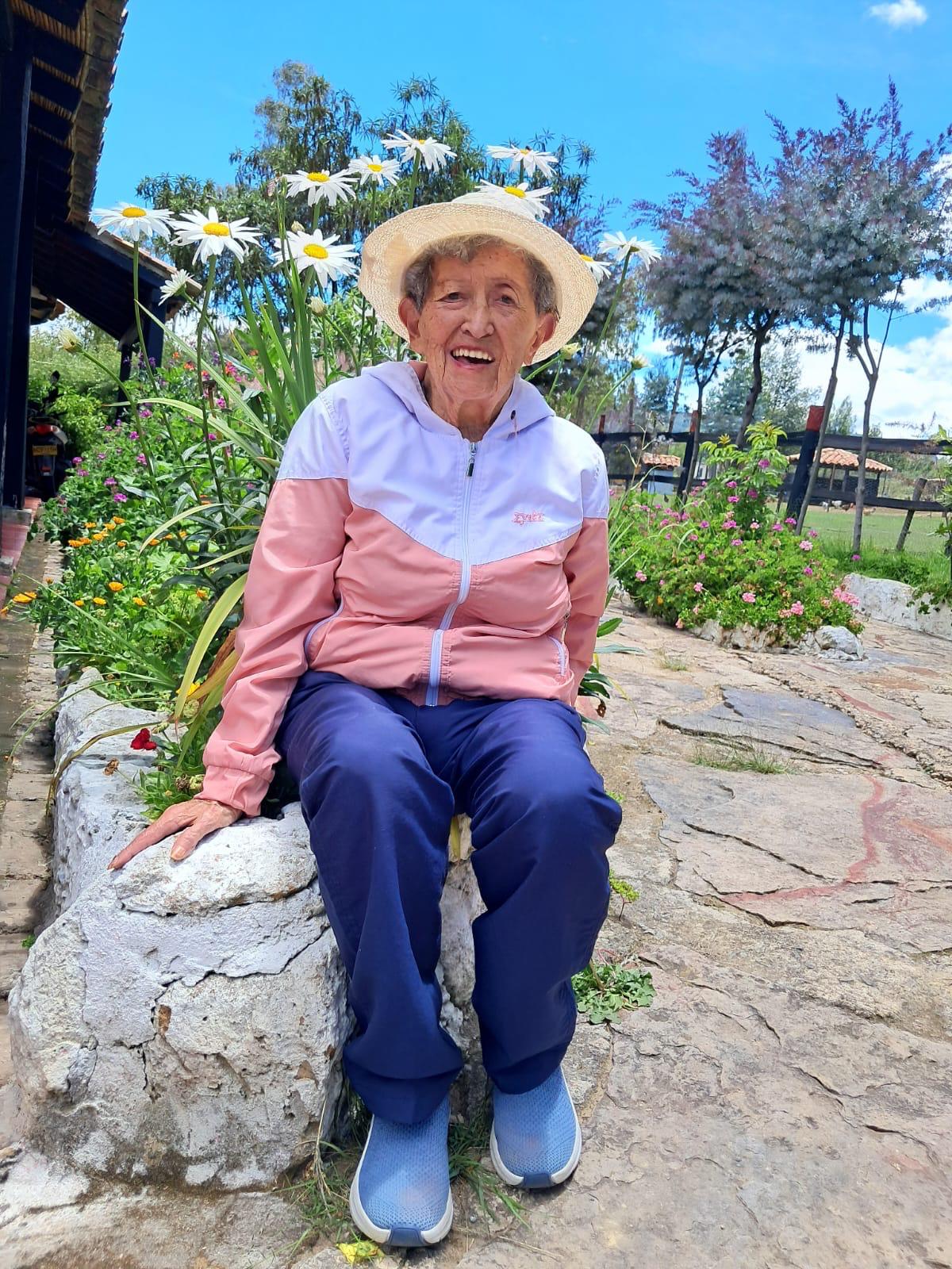 Residente sonriendo entre las margaritas del jardín